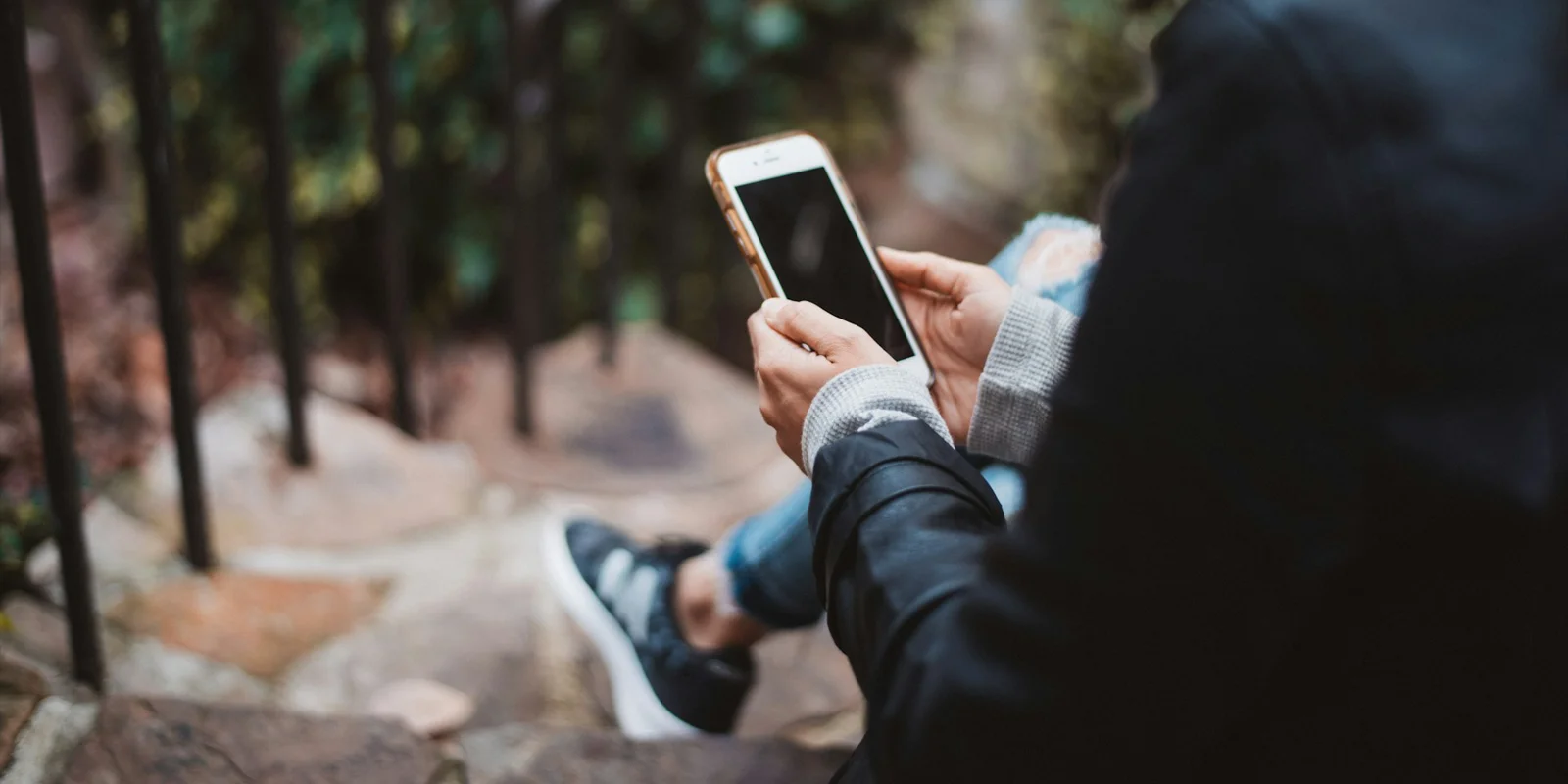 Person reading their phone outdoors.