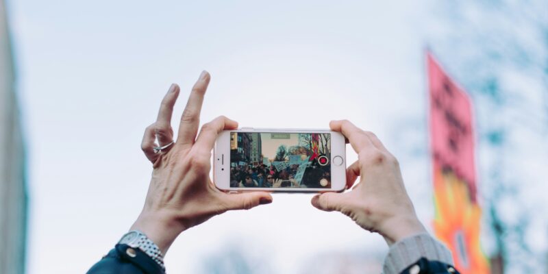 An activist holds up an iPhone to record during a protest