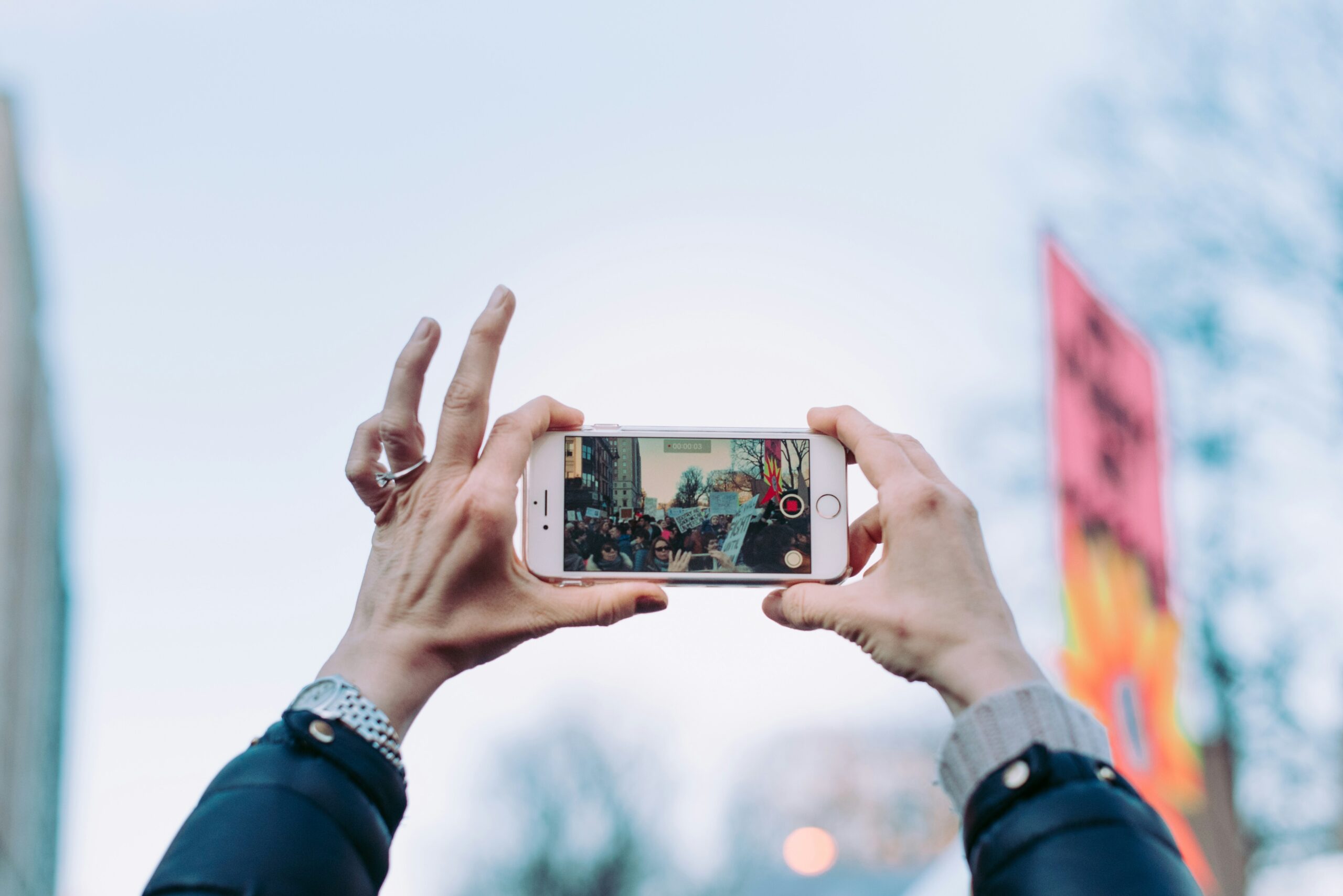 An activist holds up an iPhone to record during a protest